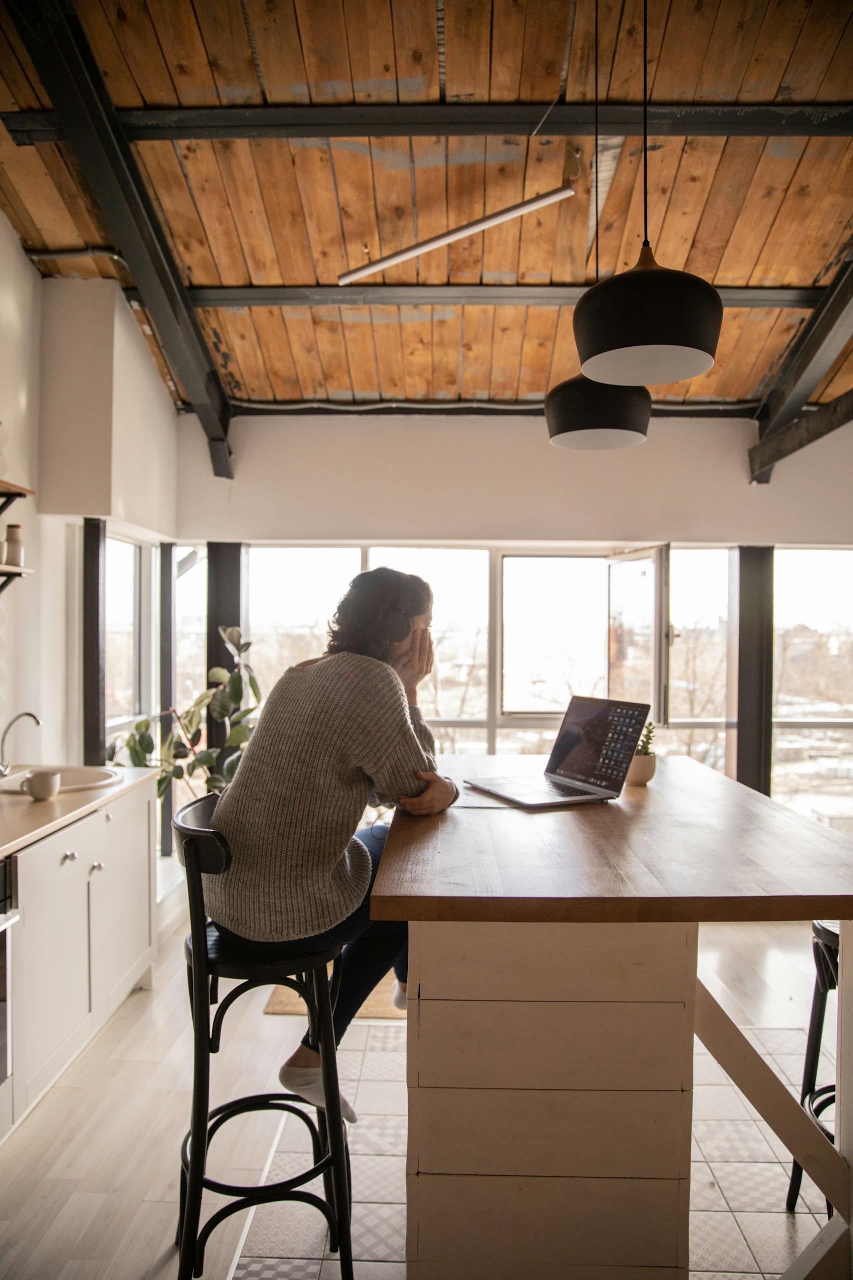Young woman looking at laptop in kitchen